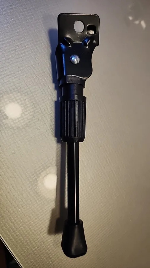 Black steel kickstand laid flat on a table, seen from the mounting plate down to the rubber foot, photographed by a verified buyer